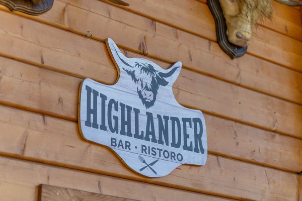 La targa Highlander Bar Ristoro sulla parete in legno